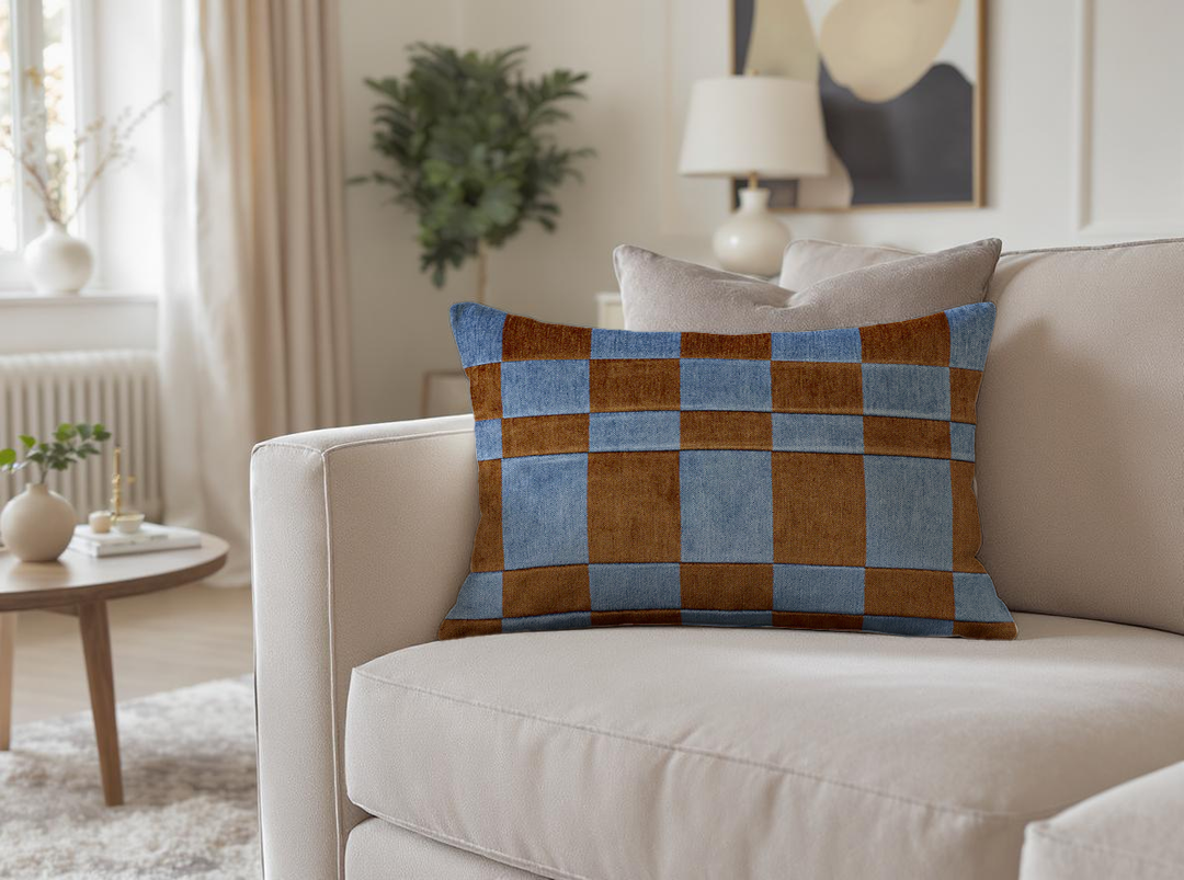 Eilersen Luna pillow in brown/blue colour on a beige sofa in a cozy, modern living room.