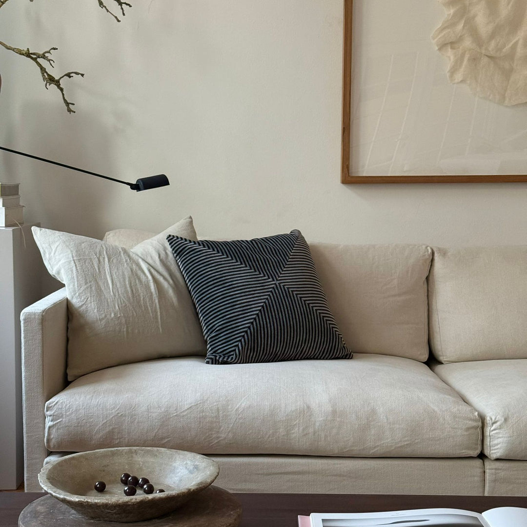 Beige sofa with decorative pillows in a living room setting