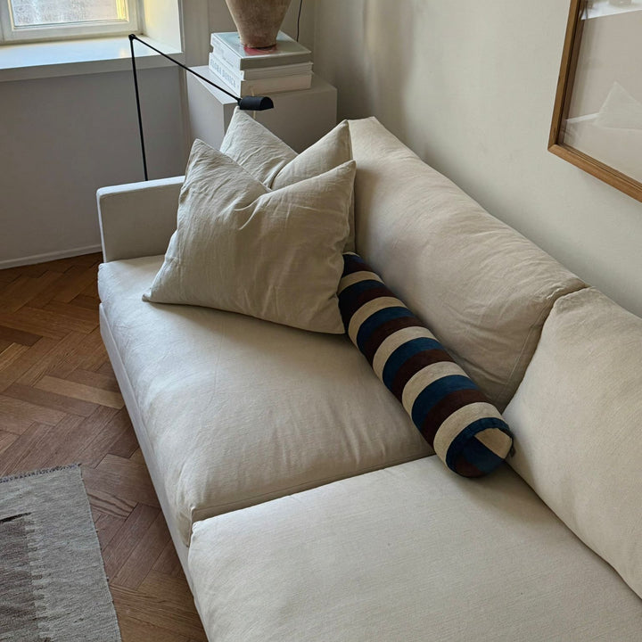 Beige sofa with decorative pillows in a living room setting